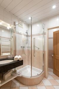 a bathroom with a shower and a tub and a sink at Hotel Zimmerbräu in St. Wolfgang