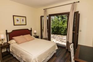 a bedroom with a bed and a sliding glass door at Villa Turistica de Bubion in Bubión