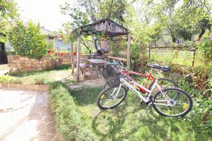 uma bicicleta estacionada na relva num jardim em Старата къща - Трявна em Tryavna