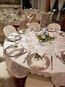 een lange tafel met witte tafels met borden en bestek bij Platani Hotel in Bolsena