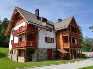 ein großes Holzhaus mit Leuten, die davor stehen in der Unterkunft Antela, 142 m2 appartment for 12 person in Mariborsko Pohorje in Hočko Pohorje