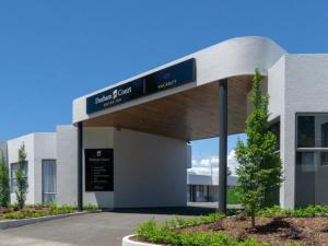 een gebouw met een bord voor een parkeerplaats bij Durham Court Motor Inn in Tauranga