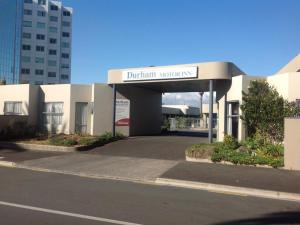 een gebouw met een bord waarop staat: Durham University bij Durham Court Motor Inn in Tauranga