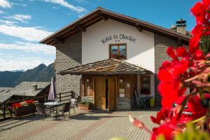 a building with a table and chairs on a patio at Hotel Le Clocher in Champoluc