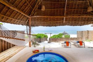 eine Hängematte am Strand mit Meerblick in der Unterkunft Zanzibar Sunrise at Bandas in Matemwe