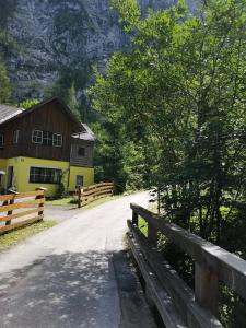 une route devant une maison avec une clôture dans l'établissement Haus Waldbach, à Hallstatt