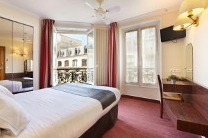 um quarto de hotel com uma cama, uma secretária e uma janela em Hotel du College de France em Paris