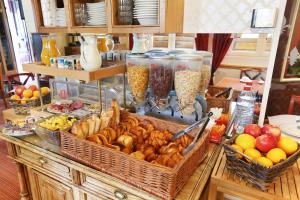 um buffet com cestas de pão e outros alimentos em Hotel du College de France em Paris