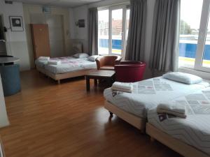 una camera con tre letti e un tavolo con sedie di Bed & Breakfast Vlissingen a Vlissingen