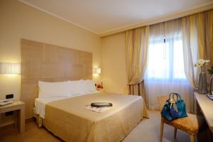 a hotel room with a large bed and a window at Best Western Hotel Rome Airport in Fiumicino