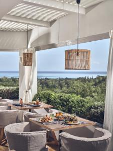 a restaurant with tables and chairs and a view of the ocean at Zante Maris Suites - Adults Only in Tsilivi