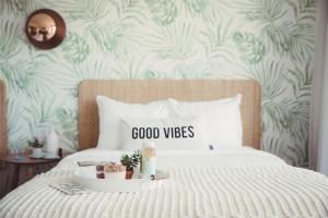 a bedroom with a bed with a good vibes sign on it at The June Motel, Prince Edward County in Picton