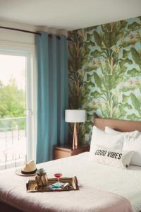 a hotel room with a bed with a tray of food on it at The June Motel, Prince Edward County in Picton