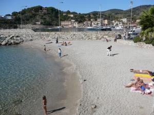 a group of people on a beach near the water at Affittacamere Vista Mare in Porto Azzurro