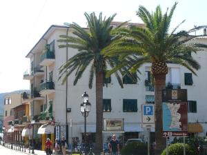 two palm trees in front of a building at Affittacamere Vista Mare in Porto Azzurro