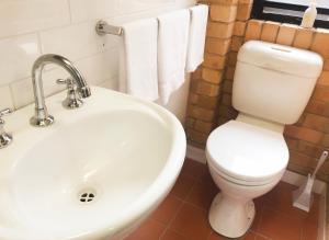 a bathroom with a white toilet and a sink at Hanbury Lodge in Newcastle