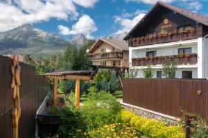 einen Zaun vor einem Haus mit Garten in der Unterkunft ASPEN in Nová Lesná