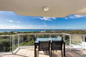 a table and chairs on a balcony with a view of the ocean at Atlantis Marcoola in Marcoola