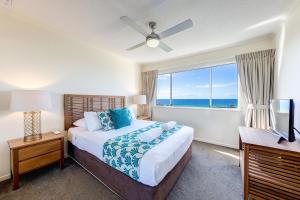 a bedroom with a bed and a window with the ocean at Atlantis Marcoola in Marcoola