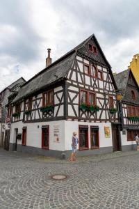 una persona in piedi di fronte a un edificio di Altkölnischer Hof a Bacharach