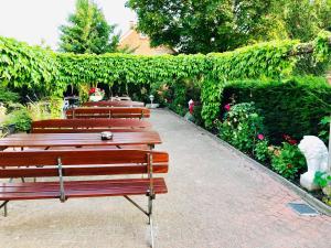 a row of benches sitting on a brick walkway at Hotel Carolinensiel Doan in Carolinensiel