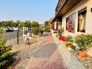 a brick walkway outside of a building with potted plants at Hotel Carolinensiel Doan in Carolinensiel