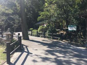 een pad in een park met een hek en bomen bij Miyajima Morinoyado in Miyajima