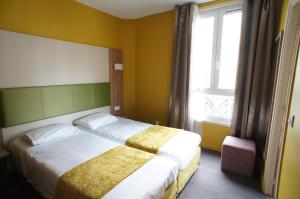 pokój hotelowy z 2 łóżkami i oknem w obiekcie Hôtel De France w mieście Boulogne-Billancourt