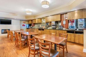 een restaurant met houten tafels en stoelen en een keuken bij Quality Inn & Suites in Brampton