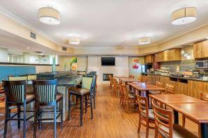 een restaurant met houten tafels en stoelen en een bar bij Quality Inn & Suites in Brampton