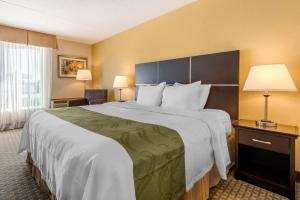 een groot bed in een hotelkamer met 2 lampen bij Quality Inn & Suites in Brampton