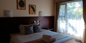 a bedroom with a bed with a large window at ZiFa Mandalika in Kuta Lombok