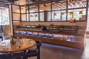 a restaurant with a table and a counter with food at Citadines OMR Chennai in Chennai