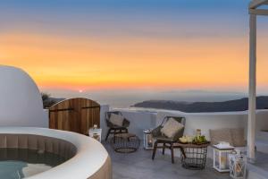 a villa with a plunge pool and a sunset at White Santorini in Imerovigli