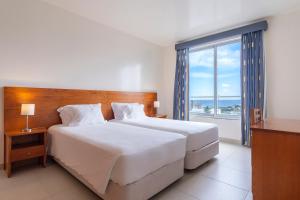 A bed or beds in a room at Acorsonho Apartamentos Turisticos