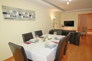 une salle à manger avec une table et des chaises blanches dans l'établissement T2 Cascais Centro, à Cascais