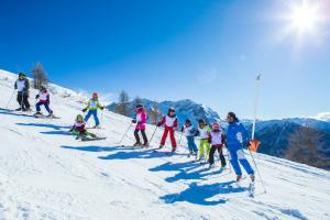 a group of people skiing down a snow covered slope at Hotel Club Uappala Sestriere in Sestriere