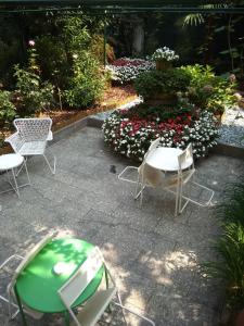 un patio con sedie e una fontana con fiori di Hotel Malta a Milano