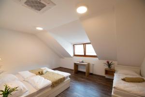 a attic bedroom with two beds and a window at Guesthouse Stari Mayr in Kranj