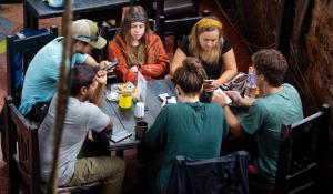 een groep mensen die rond een tafel in een restaurant zitten bij Wander Thirst in Kathmandu