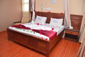 ein Bett mit roten Blumen auf einem Zimmer in der Unterkunft Pavilion Holiday Resort in Bamburi