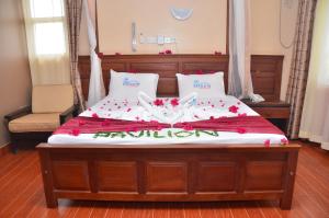 ein Bett mit roten Blumen darüber in der Unterkunft Pavilion Holiday Resort in Bamburi