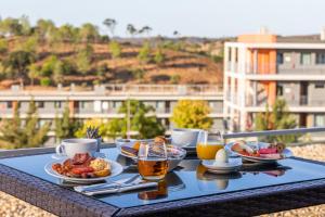 a tray of food on a table with drinks and food at Algarve Race Resort - Hotel in Montes de Cima