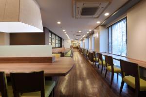 uma sala de jantar com uma mesa longa e cadeiras em Keio Presso Inn Ikebukuro em Tóquio