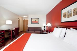 een hotelkamer met een groot bed en een bureau bij Baymont by Wyndham Merrillville in Merrillville