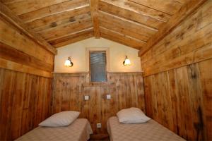 a room with two beds in a room with wooden walls at Résidence Le Portillo in Val Thorens