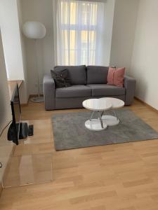 een woonkamer met een bank en een tafel bij Haus zur Eiche Private 3,5 Zimmerwohnung bis zu 8 Gäste in Chur