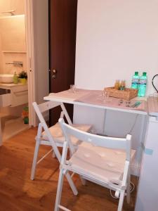 un tavolo bianco e due sedie in cucina di Welcome Home a Milano