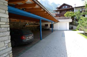 a garage with a car parked under a roof at Gästehaus Troppmair in Finkenberg