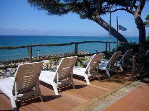 eine Reihe von Stühlen auf einer Terrasse in Strandnähe in der Unterkunft Hotel Giardino in Follonica